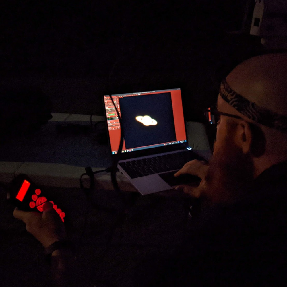 Photo of Mike looking at Saturn on a laptop screen